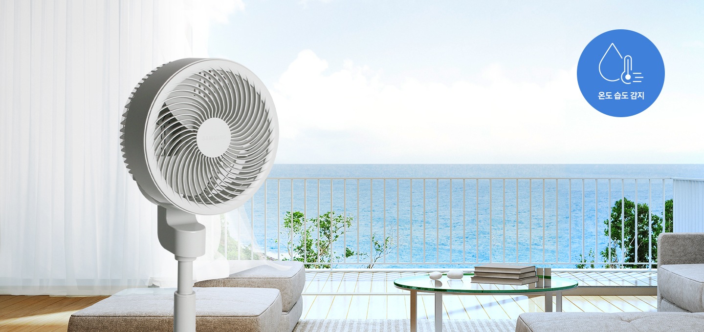푸른 바다가 보이는 테라스에 선풍기가 놓여져 있습니다. 온도 습도 감지 아이콘이 보입니다.