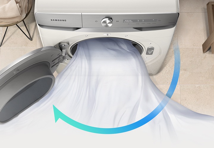 욕실로 보이는 공간에 삼성 그랑데 건조기 AI 제품이 놓여져 있습니다. 왼쪽 선반에는 수건이 쌓여져 있고 그 밑에는 바구니가 있습니다.