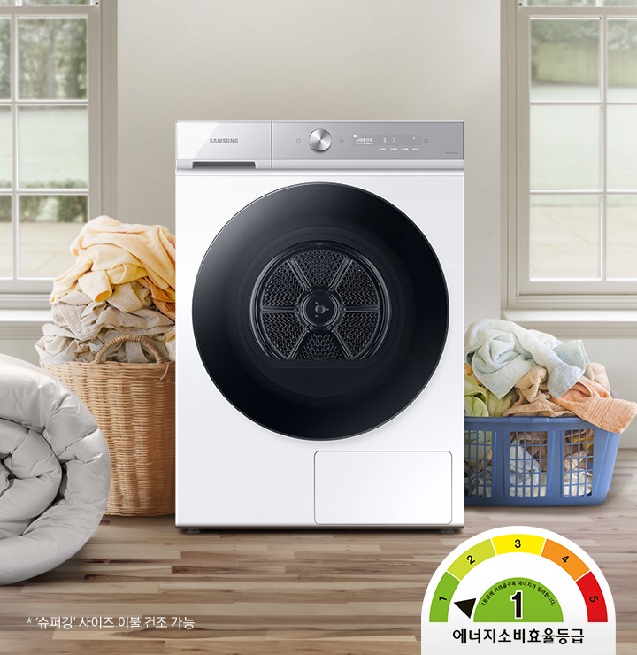 욕실로 보이는 공간에 삼성 그랑데 건조기 AI 제품이 놓여져 있습니다. 왼쪽 선반에는 수건이 쌓여져 있고 그 밑에는 바구니가 있습니다.
