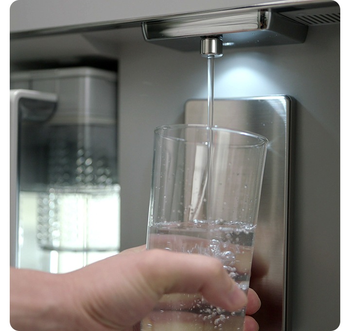 정수기 냉장고에서 컵에 물을 받는 모습입니다.