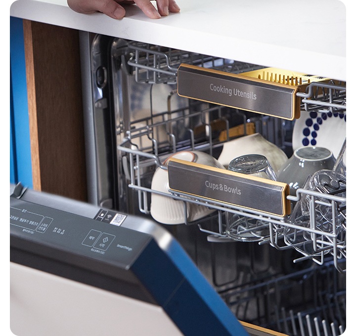 식기세척기를 여는 모습입니다. 식기세척이 내부에 그릇들이 있습니다.