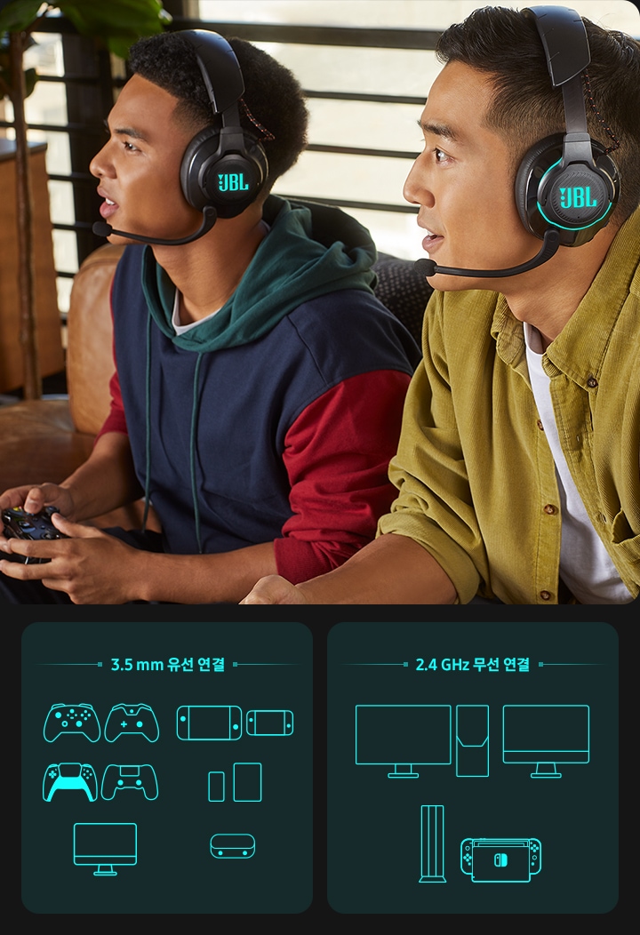 남성 2명이 JBL QUANTUM 810 헤드셋을 착용하고 게임을 하고 있는 모습입니다. 3.5 mm 유선 연결을 할 수 있는 콘솔들과 2.4 GHz 무선 연결이 가능한 게임 본체들을 보여주고 있습니다.