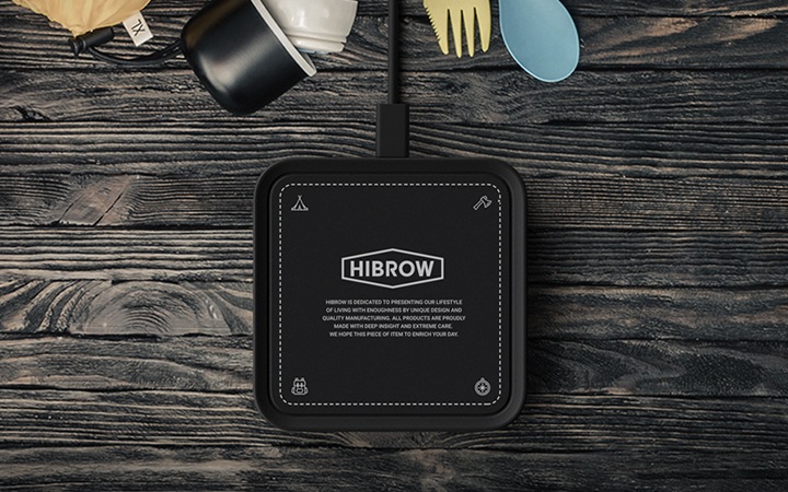 우드 테이블  위에 하이브로우 무선 충전기가 중앙에 놓여있습니다.