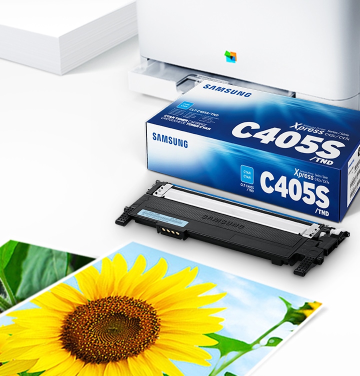 위쪽 삼성 프린터가 하단에는 출력물이 놓여있습니다. 오른쪽 하단에는 삼성 토너 카트리지가 있습니다.