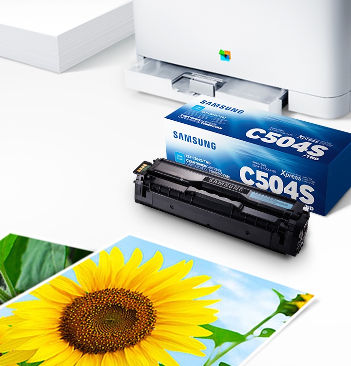 위쪽 삼성 프린터에서 출력물이 나오고 있고, 아래쪽 삼성 토너 카트리지가 있습니다.