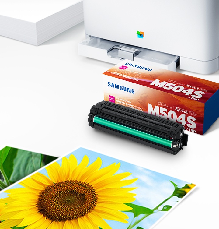 위쪽 삼성 프린터에서 출력물이 나오고 있고, 아래쪽 삼성 토너 카트리지가 있습니다.