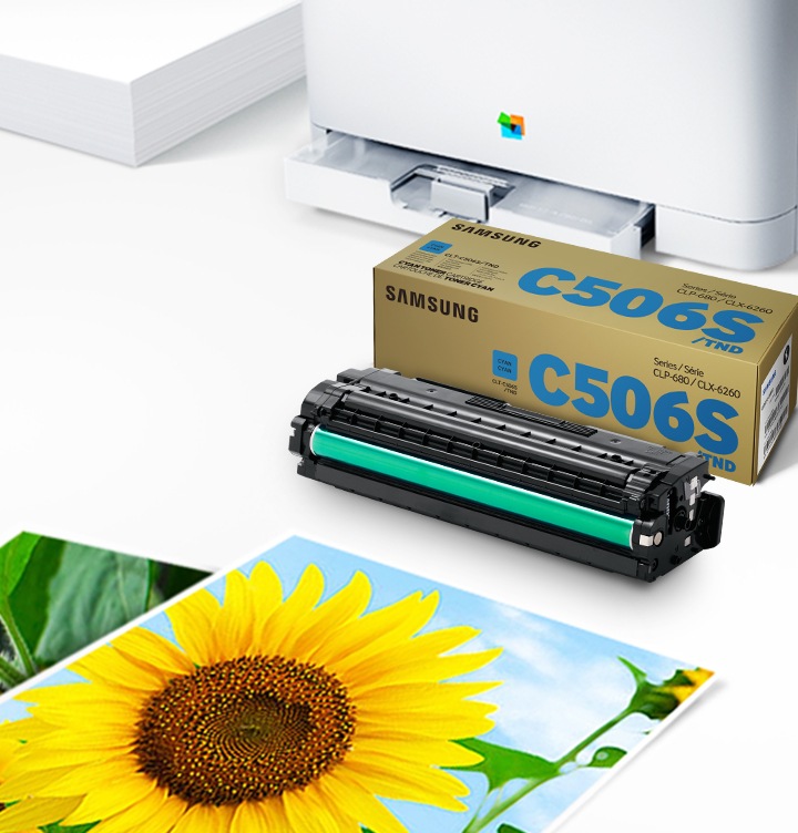 위쪽 삼성 프린터에서 출력물이 나오고 있고, 아래쪽 삼성 토너 카트리지가 있습니다.