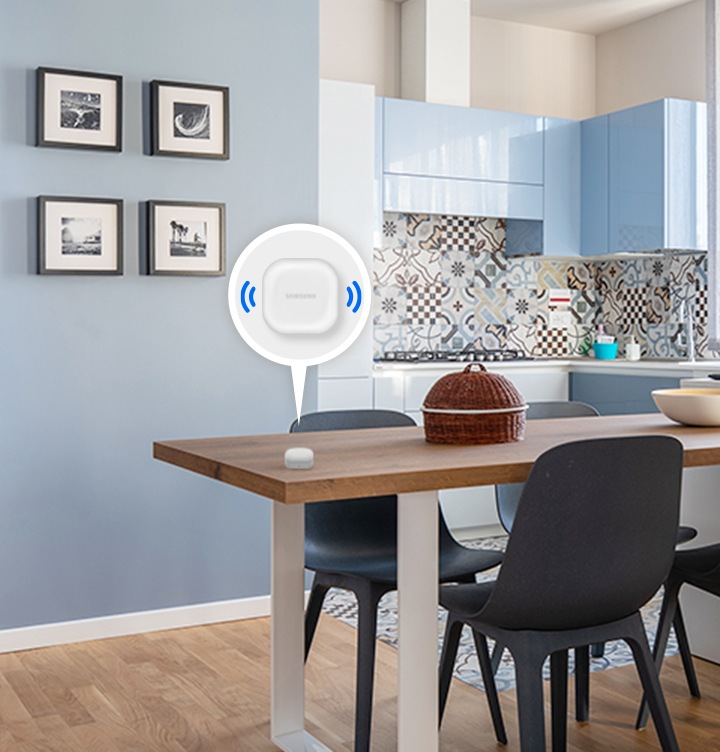 탁자 위에 갤럭시 버즈가 놓여져 있고, 그 버즈 위에 말풍선이 떠있습니다. 말풍선 안에는 버즈가 있고, 버즈의 양 옆에 소리가 울리는듯한 아이콘이 그려져 있습니다.