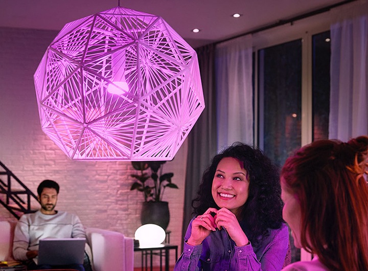 휴 브릿지를 사용한 스마트 조명이 켜져있고 여성이 바라보고 있습니다.