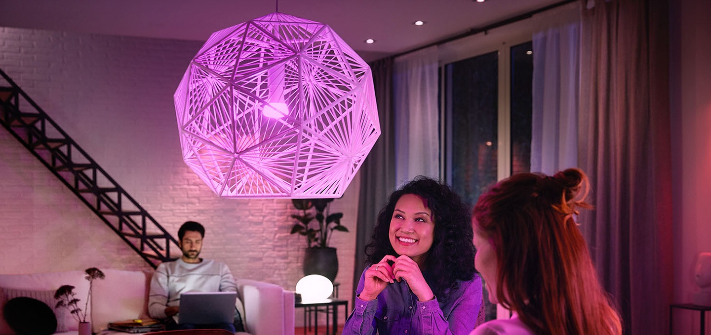 휴 브릿지를 사용한 스마트 조명이 켜져있고 여성이 바라보고 있습니다.