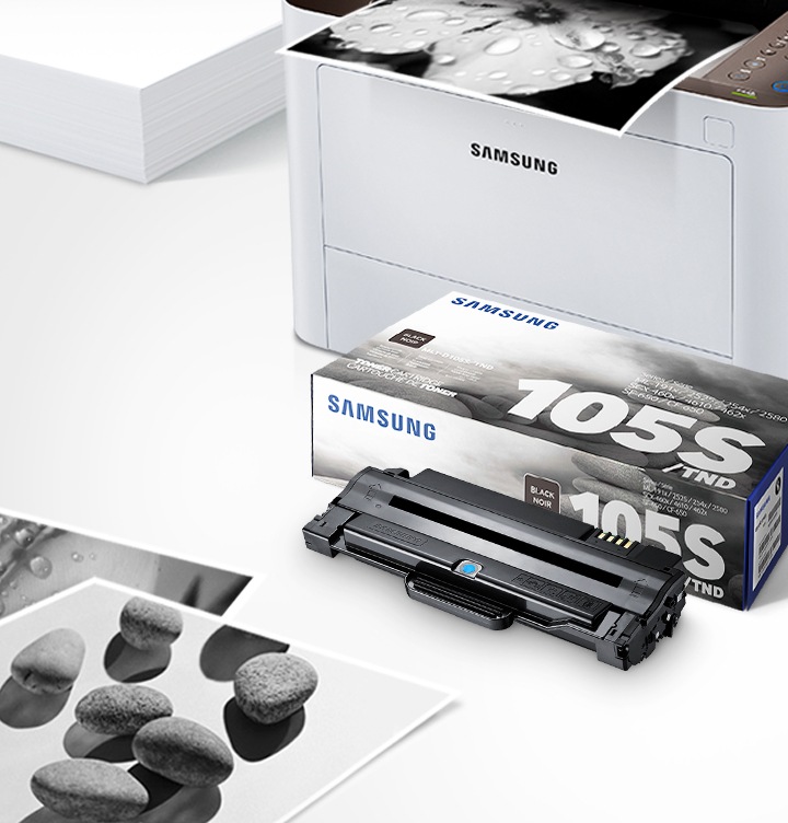 위쪽 삼성 프린터에서 출력물이 나오고 있고, 아래쪽 삼성 토너 카트리지가 있습니다.