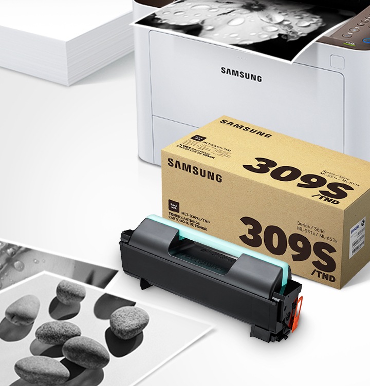 위쪽 삼성 프린터에서 출력물이 나오고 있고, 아래쪽 삼성 토너 카트리지가 있습니다.