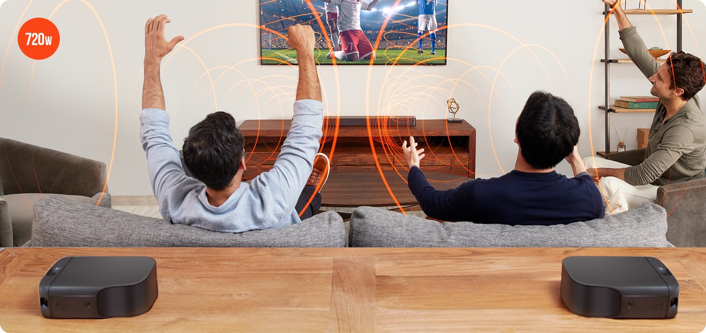 넓은 거실에서 남자 3명이 소파에 앉아 정면에 있는 TV와  JBL BAR 800 사운드바의 생생한 음질로 축구경기를 시정하고 있습니다.  이러한 이미지 위에 붉은색의 원형 음파효과를 삽입하여  시각적인 효과까지 더하고 있습니다. 