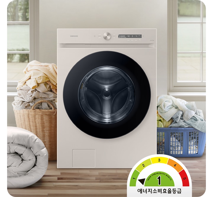 정면 가운데에 그랑데AI 세탁기 정면샷이 보입니다. 세탁기의 왼편에는 대형이불이있고 좌우로 많은 빨래가 보입니다. 화면 오른쪽 끝에는 바구리를 머리에 쓰고 웃고 있는 아이의 모습이 보입니다. 왼편 상단 위에는 에너지 소비효율 1등급 표시가 되어 있습니다.
