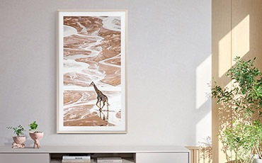 벽걸이 TV가 세로모드로 설치되어 있고 화면에는 화려한 색감의 이미지가 보입니다.