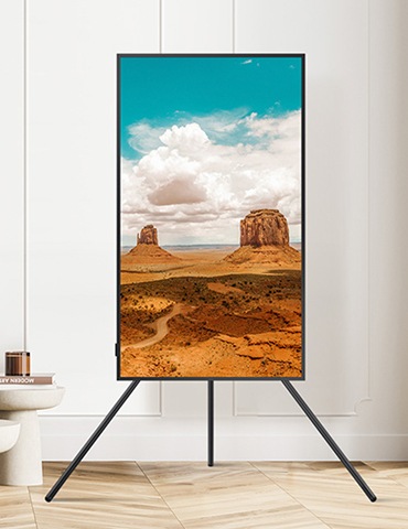 벽걸이 TV가 세로모드로 설치되어있고, 화면에는 붉은 사막 모습이 보입니다.