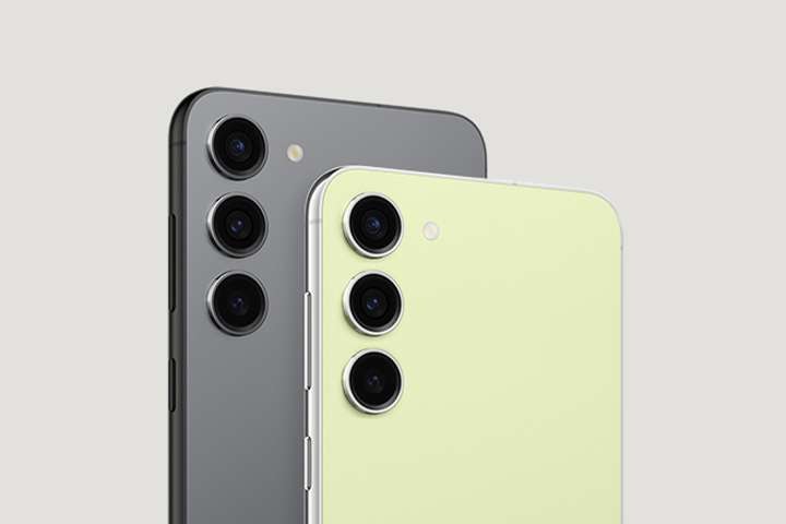 그라파이트 색상의 갤럭시 S23 앞에 라임 색상의 갤럭시 S23이 똑바로 세워져 있습니다. 두 대 모두 뒷면이 정면을 향하고 있으며 우측으로 비스듬하게 세워져 있습니다.