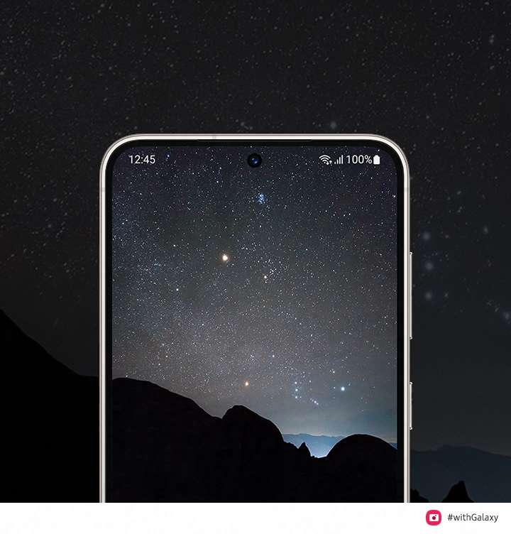 어두운 밤하늘을 배경으로 중앙에는 S23의 화면이 있고, 화면 안에는 색감이 선명하게 살아난 밤하늘의 모습이 보여지고 있습니다.