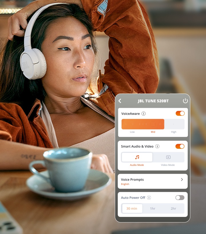 차 한잔을 앞에 두고 JBL TUNE 520BT를 착용하고 음악감상 중인 여성과 Voice Aware 제어 화면이 보입니다.