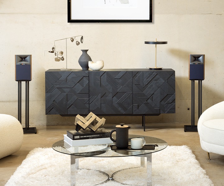 거실장 양 옆에 스탠드에 거치된 4305P 스피커가 배치되어 있습니다.