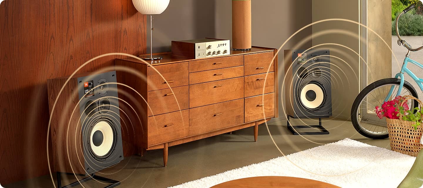 가구 양 옆으로 L100 스피커가 배치되어 있으며, 스피커에서 음파가 나오고 있는 모습입니다.