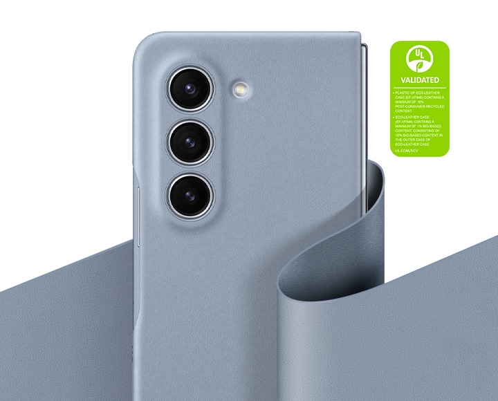 아이스 블루 색상의 비건 레더 케이스가 씌워진 갤럭시 Z 폴드5가 접힌 상태로 똑바로 세워져 있습니다. 아이스 블루 색상의 비건 레더 조각이 기기를 우아하게 감싸고 있습니다. 다음과 같은 문구가 쓰여 있습니다. 비건 레더 케이스(EF-VF946)의 플라스틱에는 최소 16 %의 재활용 소재가 포함되어 있습니다. 비건 레더 케이스(EF-VF946)에는 최소 1 %의 바이오 소재가 포함되어 있으며, 비건 레더 케이스의 외부 케이스에는 10 %의 바이오 소재가 포함되어 있습니다. 