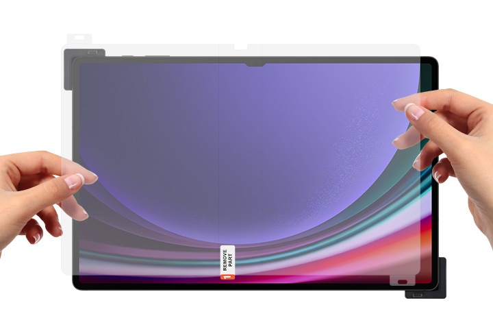 갤럭시 탭이 보여지며 그 위에 갤럭시 탭 S9 Ultra AR 스크린 프로텍터를 손으로 잡고 있는 모습이 보여집니다.