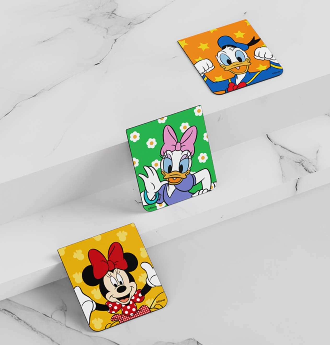 계단식 대리석 배경이 보여집니다. 갤럭시 Z 플립5 디즈니 플립수트 카드(3매)가 차례대로 보여지고 있으며 오른쪽 상단에 도날드덕 플립카드가 보여지며, 중간에 데이지 플립카드가 계단에 기울어져 보여지며, 왼쪽 하단에 미니마우스 플립카드가 계단에 기울어져 보여집니다.