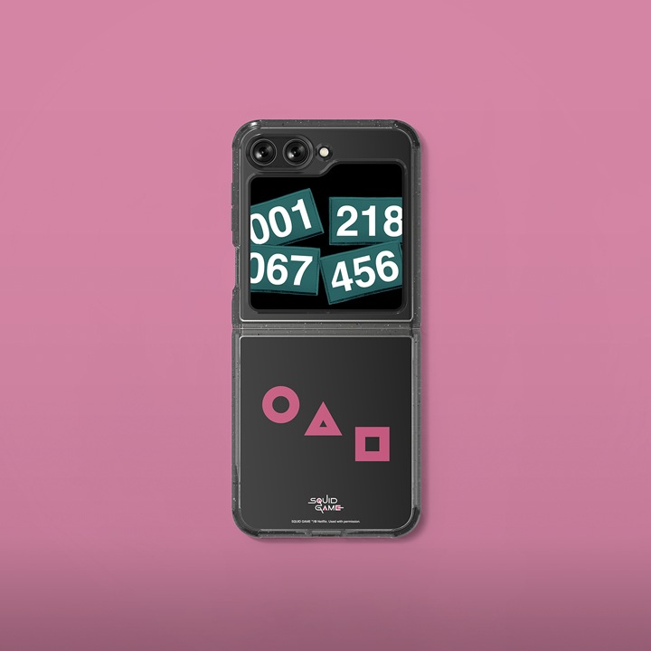 오징어 게임 수트 케이스 with 플립수트 카드가 장착된 갤럭시 Z플립이 배치되어 있습니다.