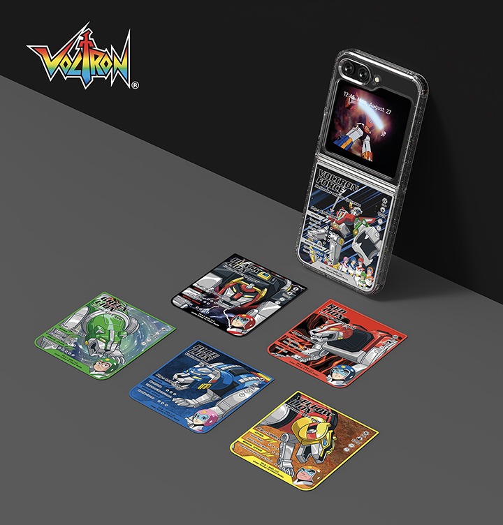 회색 바닥과 검정색 벽이 배경으로 보이며 왼쪽 상단에 볼트론 로고가 보여집니다. 갤럭시 Z 플립5 볼트론 수트 케이스와 플립수트 카드 장착된 갤럭시 Z 플립5 이미지가 벽에 기울어져 보여집니다. 아래에는 5장의 볼트론 플립수트 카드가 보여집니다.