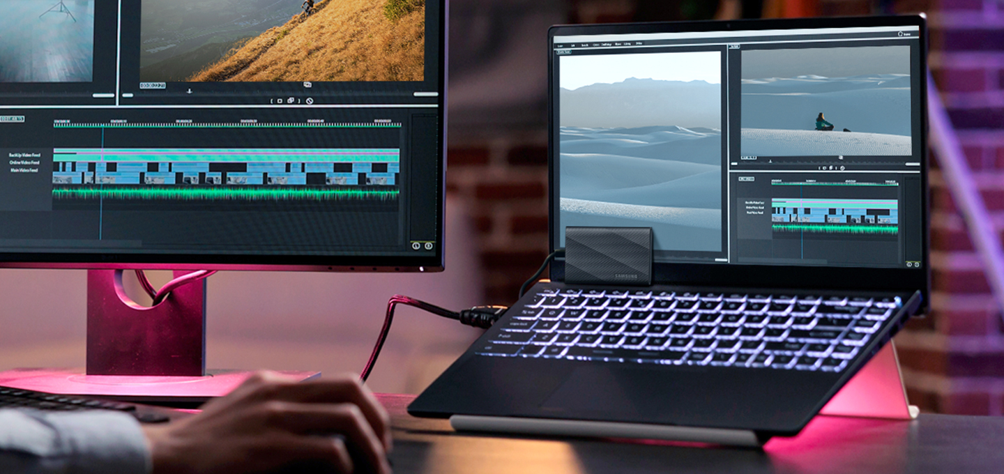 이미지의 분홍색 조명이 배경에 깔려 있으며 이미지의 오른쪽에는 노트북이 거치대에 거치되어 있고 외장 SSD T9 USB 제품을 노트북에 연결하여 노트북 화면 앞에 세워 놓은 제품 정면 이미지와 왼쪽에는 모니터를 이용하여 작업을 하는 모습을 보여주는 이미지 입니다.