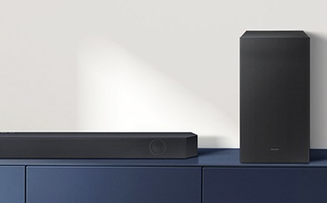 제품과 스피커가 놓여 있으며 제품 정면이 보입니다.