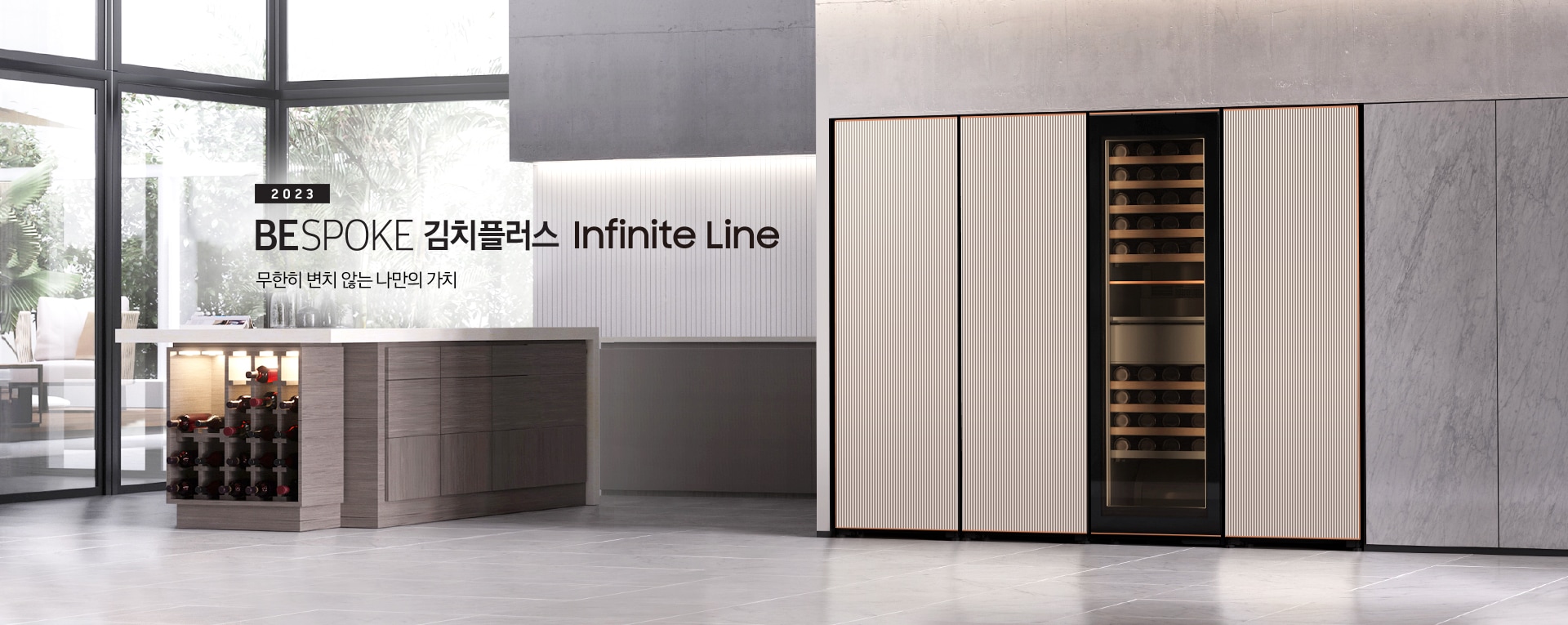 주방 냉장고장에 타임리스 그레이지 컬러의 인피니트 라인 1도어 냉동고, 김치냉장고, 투명 패널의 와인냉장고, 1도어 냉장고가 빌트인 되어 있으며 냉장고장 우측에는 '2023 BESPOKE 김치플러스 Infinite Line 무한히 변치 않는 나만의 가치' 문구가 있습니다. 