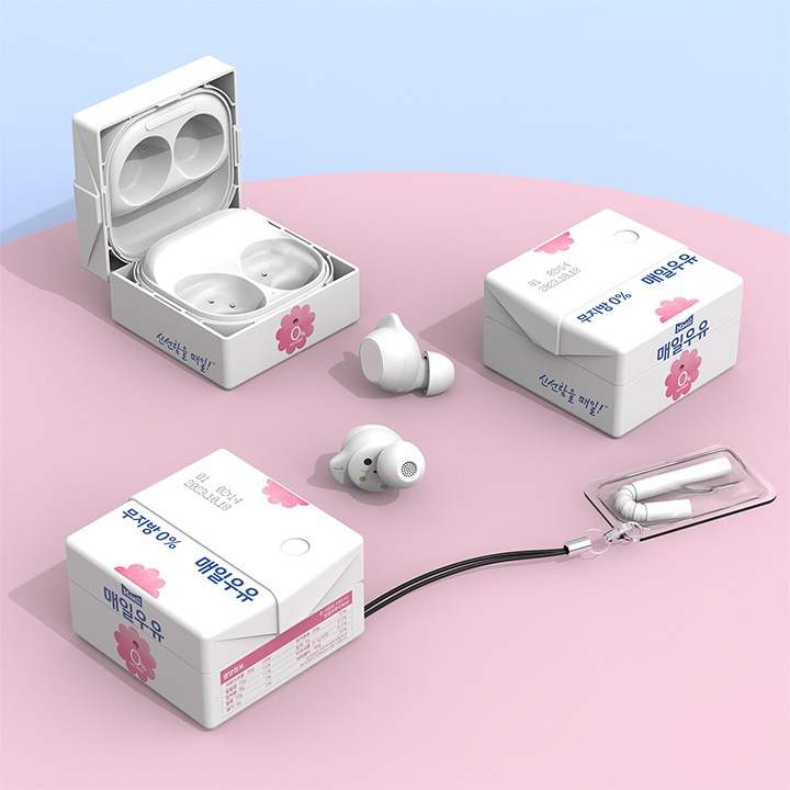 파란색 배경에 연한 분홍색 원형 받침대에 갤럭시 버즈 매일우유 케이스 (무지방)에 버즈가 장착되어 버즈케이스가 오픈되어 있으며, 그 아래 이어버드가 보여집니다. 이어버스 양 옆에 갤럭시 버즈 매일우유 케이스 (무지방)이 보여지며 아래의 갤럭시 버즈 매일우유 케이스 (무지방)에는 빨대 키링이 장착되어 있는 이미지가 보여집니다.