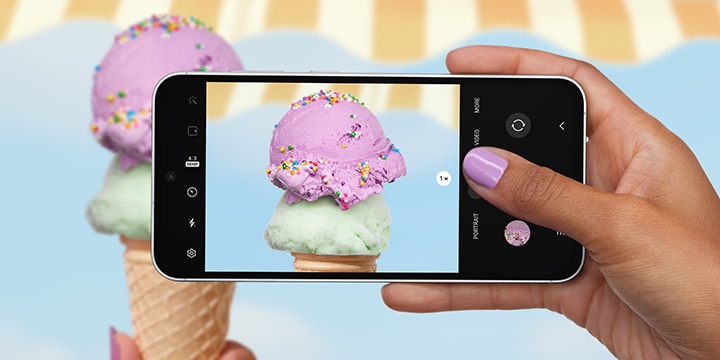 갤럭시 S23 FE 기기를 가로 모드로 손에 쥐고 사진을 촬영하고 있는 화면입니다. 다채로운 스프링클이 뿌려진 스쿱 아이스크림이 선명하고 디테일하게 표시되어 있습니다. 