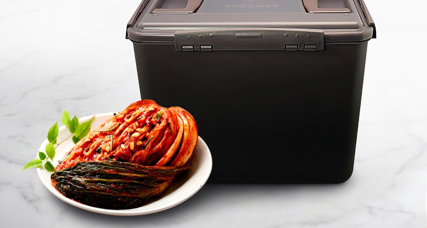 김치통 모서리 부분을 클로즈업하여 보여주고 있으며 좌측에는 접시위에 김치가 놓여져 있습니다.