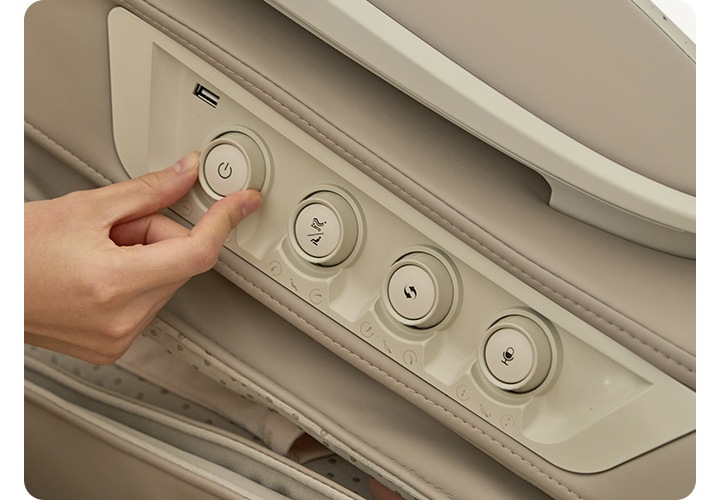 코지마 안마의자의 서브 리모컨이 보이며 손으로 회전하며 조절하는 모습이 보입니다.