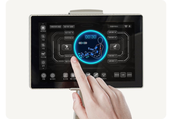 코지마 안마의자의 리모컨이 보이며 손으로 터치하는 모습이 보입니다.