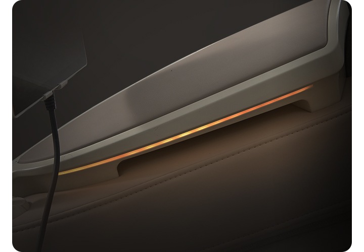 코지마 안마의자의 측면이 위, 아래로 나뉘어서 보입니다. 어두운 배경에 LED가 켜져 보입니다.