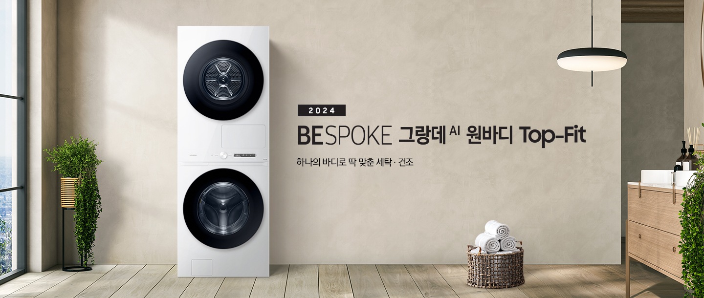 베이지 톤의 욕실 공간에 BESPOKE 그랑데 AI 원바디 Top-Fit 제품이 놓여 있습니다. 우측에는 세면대 있고 BESPOKE 그랑데 AI 원바디 Top-Fit 제품과 세면대 사이에는 바구니 안에 수건있습니다. 