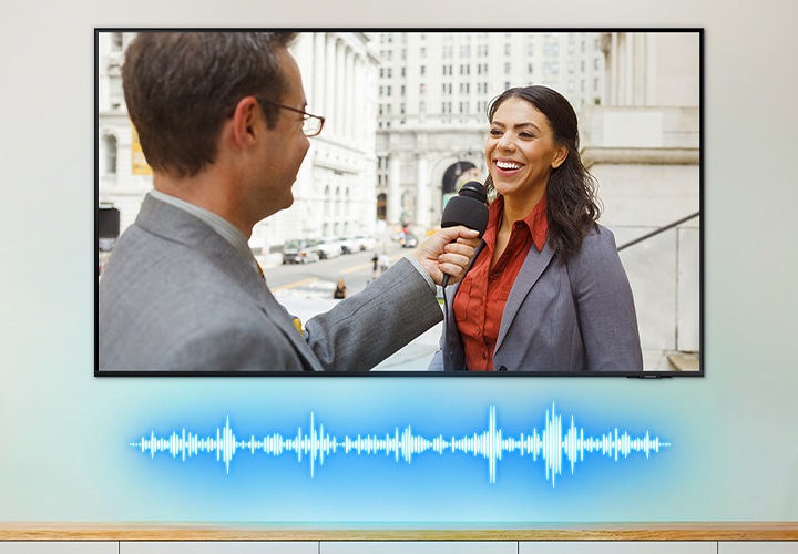 TV 화면 속 남성이 여성을 인터뷰하는 모습이 보입니다. TV 하단에는 음향효과가 보입니다.