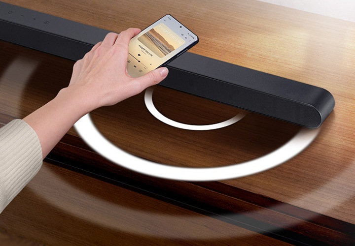 사용자의 손이 보이고 사운드바에 탭하는 이미지가 보입니다.