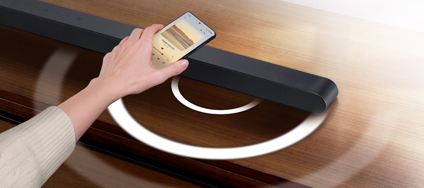 사용자의 손이 보이고 사운드바에 탭하는 이미지가 보입니다.