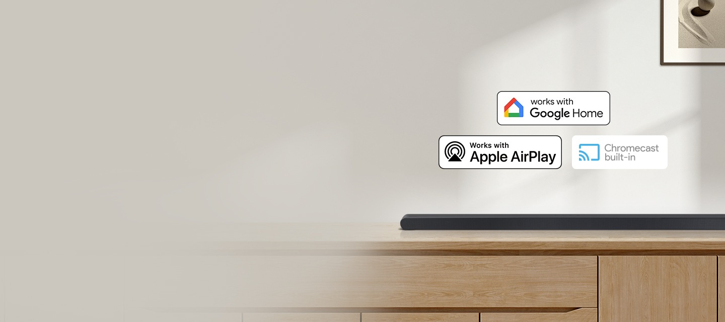 장식장 위에 사운드바가 올려져 있습니다. 사운드바 위에는 구글홈, 애플 에어플레이, 크롬캐스트 빌트인 아이콘이 있습니다.