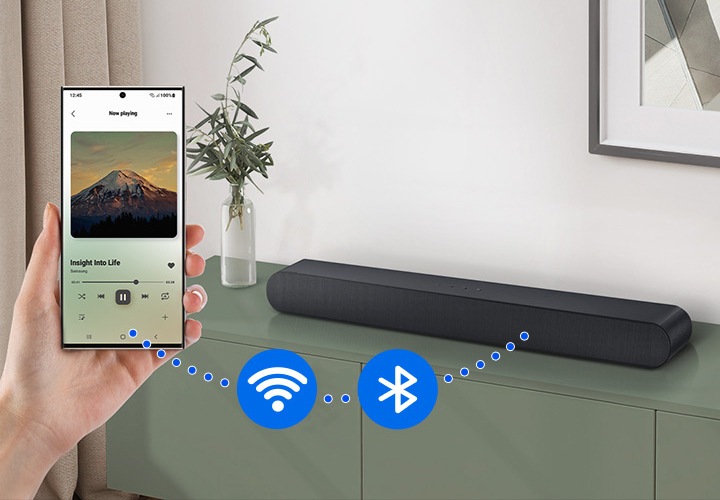 스마트폰과 사운드바 사이에 점선이 연결되어 있으며 그 사이에 Wi-Fi 아이콘과 블루투스 아이콘 있습니다.