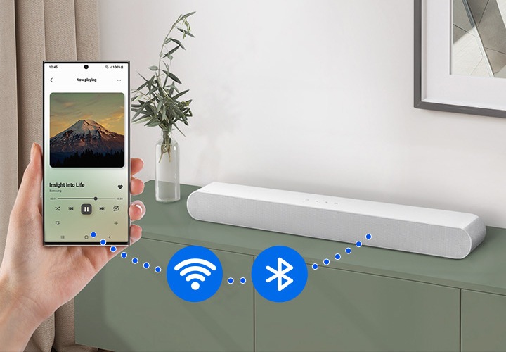 스마트폰과 사운드바 사이에 점선이 연결되어 있으며 그 사이에 Wi-Fi 아이콘과 블루투스 아이콘 있습니다.