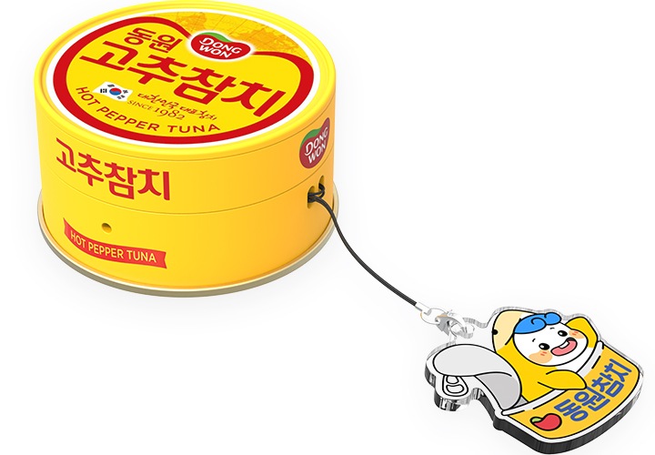 이미지 중간에서 동원참치의 마스코트 ‘다랑이’ 키링을 장착한 갤럭시 버즈 동원 고추참치 케이스를 버즈에 장착 후 오른쪽 상단에서 내려본 이미지가 보이고 있습니다.