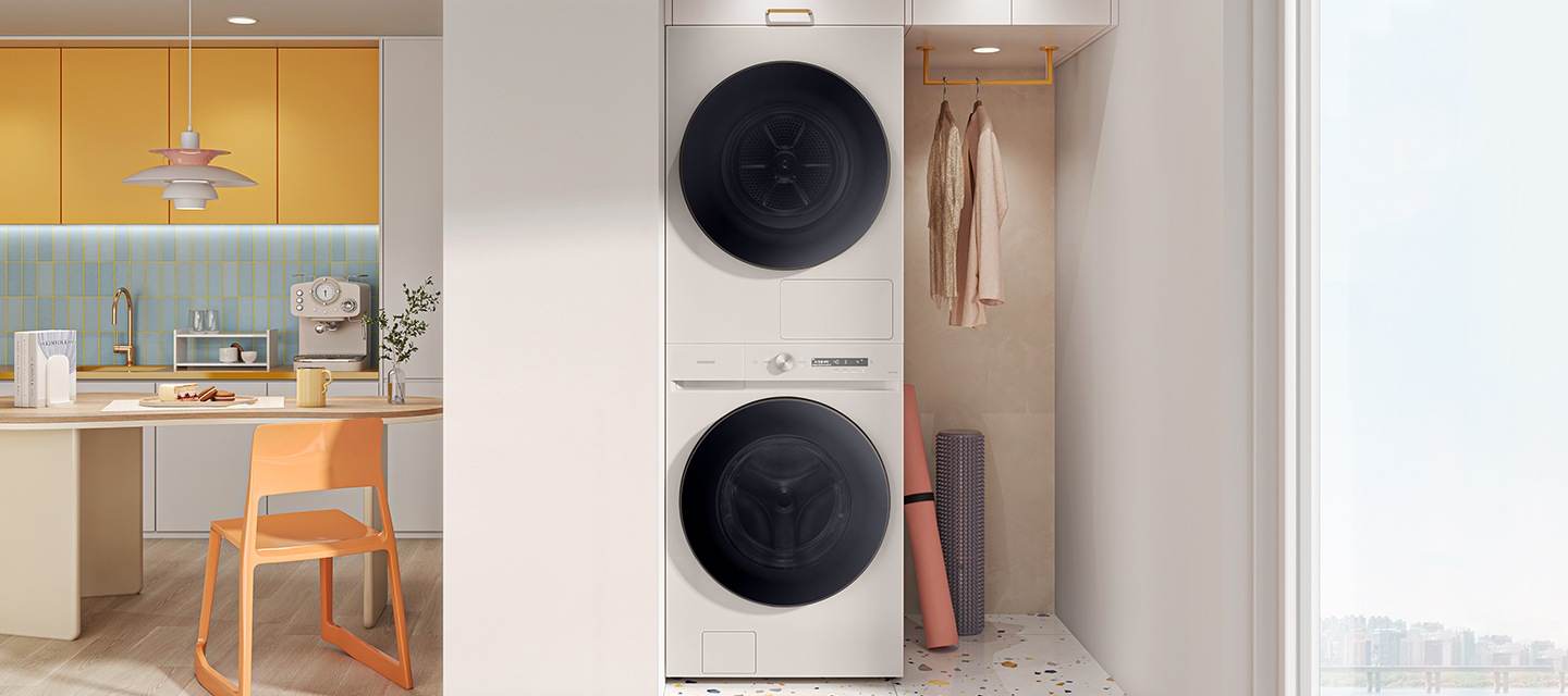 전체적으로 핑크색으로 주방에 화이트 색 원바디 제품이 있습니다. 제품 죄측에는 주방 서랍장 있고,  우측에는 식탐과 의자가 있습니다. 의자 뒤에는 다용도실 문이 보이고 옆에는 벽걸이 그림이 있습니다.