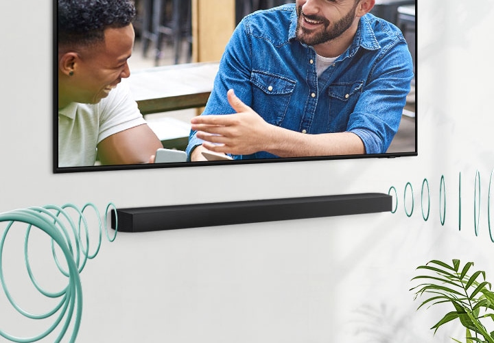 벽면에 설치된 TV 화면 속 남성들이 대화를 나누는 모습입니다. TV 하단에 설치된 삼성 사운드바에서 음향이 나오는 모양을 둥근 음파 모양으로 표현하여 보여주고 있습니다.,