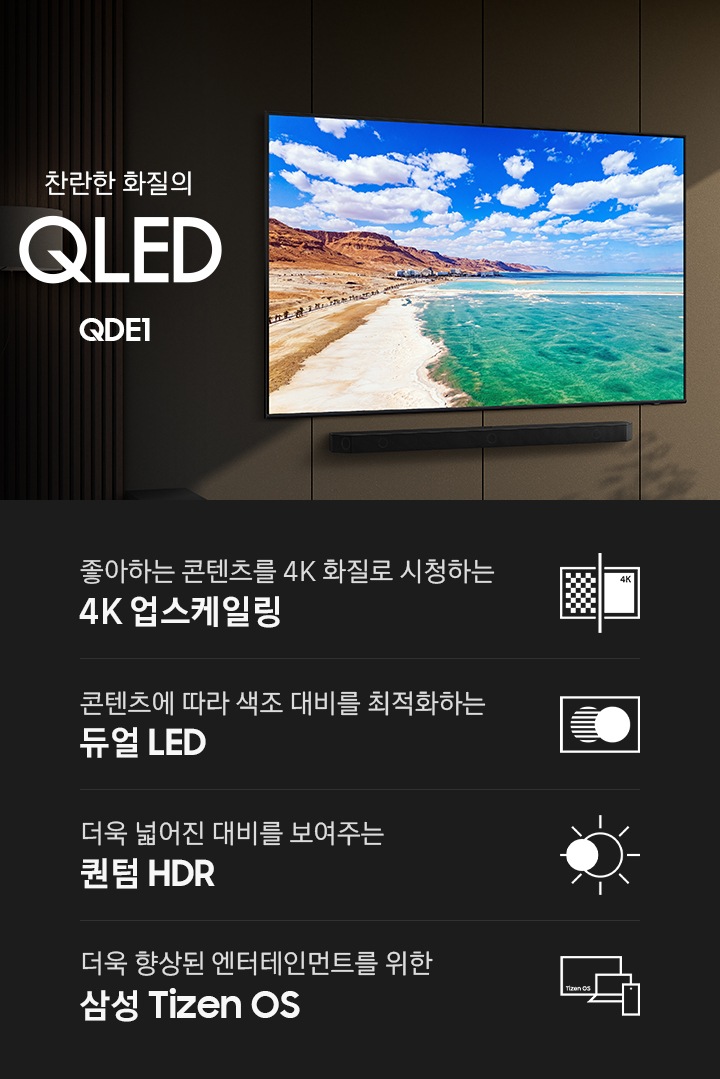 벽면에 TV와 사운드바가 설치되어 있습니다. TV 화면에는 해변이 보입니다. TV 오른쪽에는 장식장이 있으며, 장식장에는 책과 장식품이 놓여 있습니다. 찬란한 화질의 QLED QDE1 KV입니다. KV 하단에는 좋아하는 콘텐츠를 4K 화질로 신청하는 4K 업스케일링, 콘텐츠에 따라 색조 대비를 최적화하는 듀얼 LED, 더욱 넓어진 대비를 보여주는 퀀텀 HDR, 더욱 향상된 엔터테인먼트를 위한 삼성 Tizen OS 문구와 아이콘이 있습니다.
